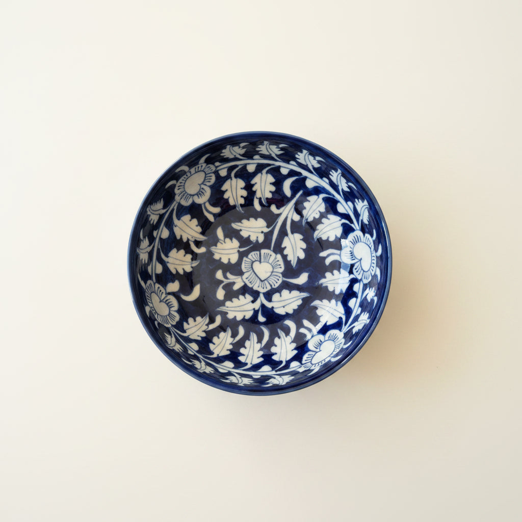 A round ceramic bowl with a dark blue and white floral pattern. 