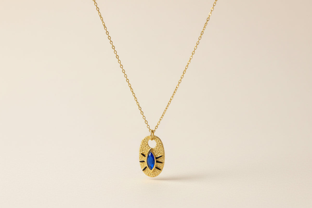 Close up of a Gold Necklace with a Blue Eye Pendant