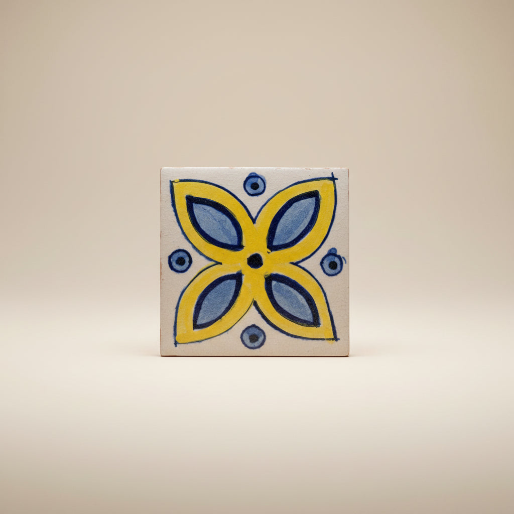 White pottery tile with a symmetric blue and yellow design