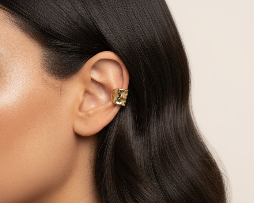 Dark haired woman wearing golden ear cuff