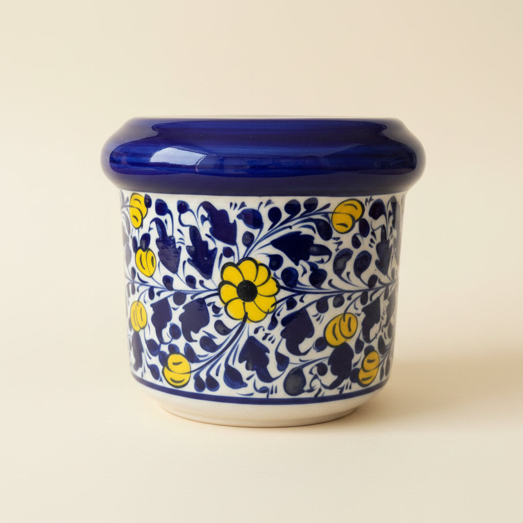 A ceramic jar with a glossy cobalt blue lid and a white body decorated with a traditional blue and yellow floral pattern.