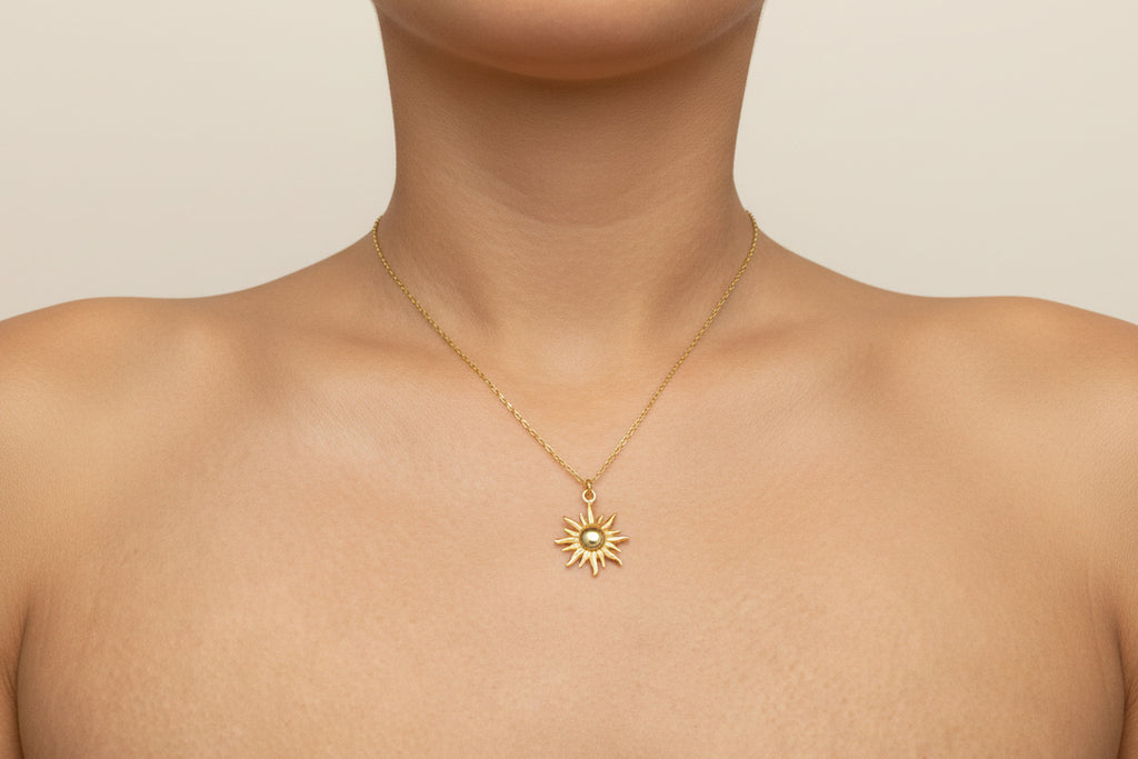 Gold necklace with a sun pendant worn by a woman