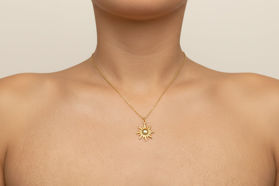 Gold necklace with a sun pendant worn by a woman