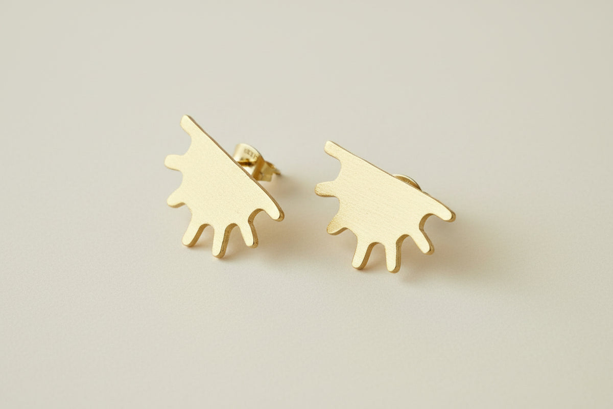 Gold earrings that feature the shape of half a sun