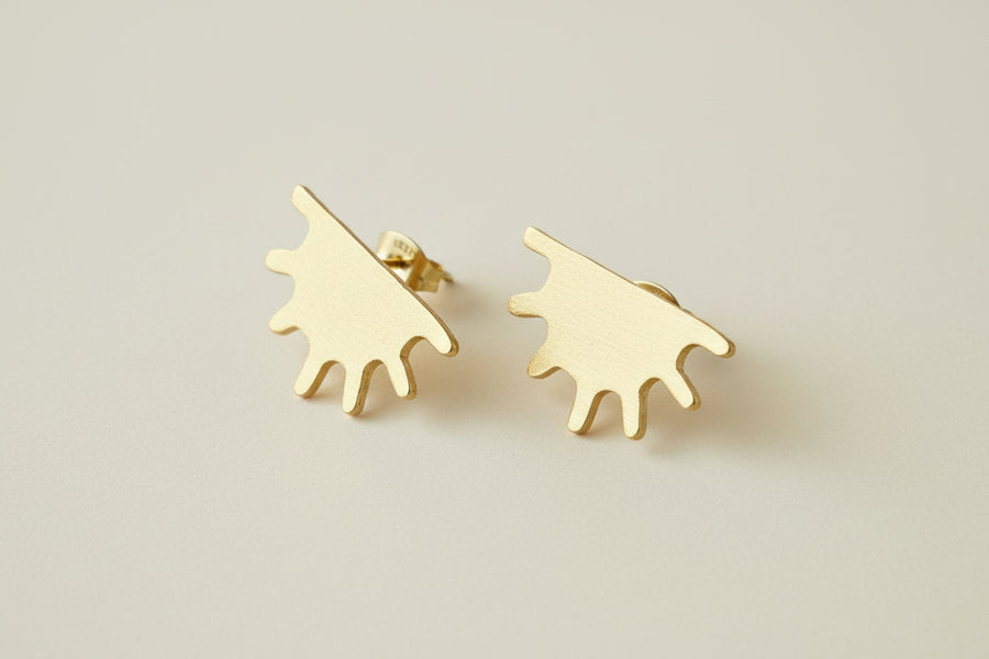 Gold earrings that feature the shape of half a sun