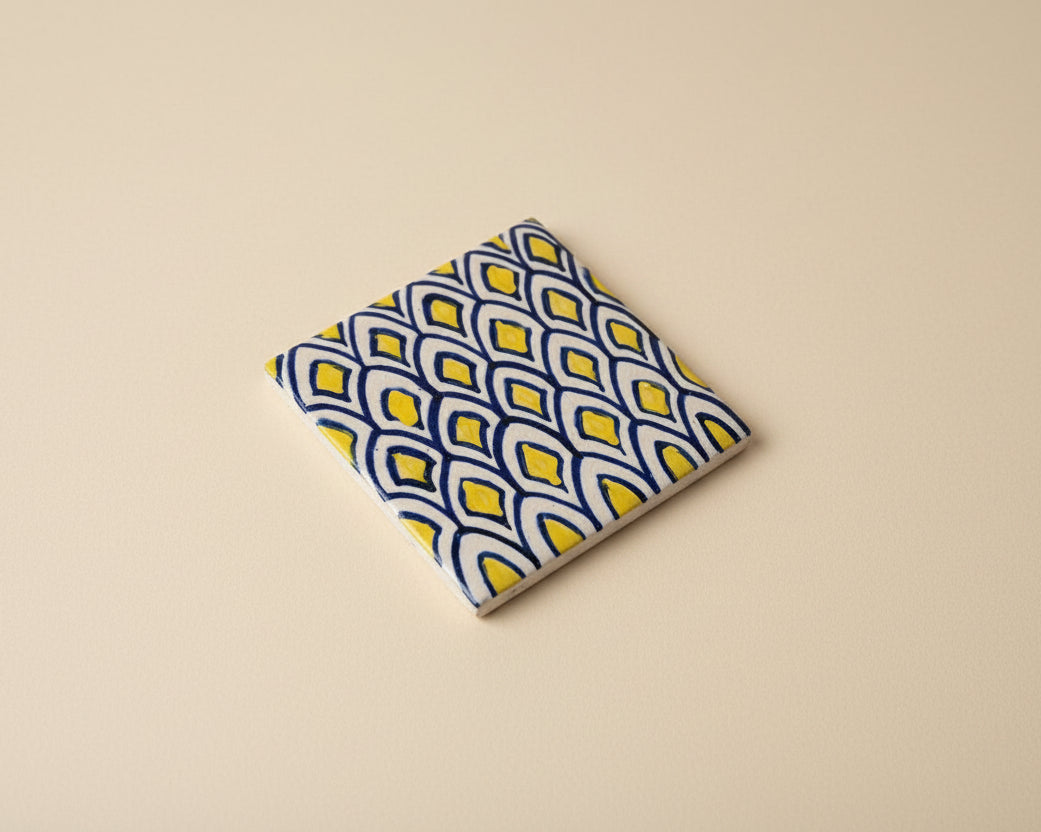 Handmade pottery tile with a blue and yellow design
